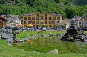 a town with a pond in front of a building at Hotel Grand Usseglio in Usseglio