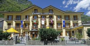 a large yellow building with blue signs on it at Hotel Grand Usseglio in Usseglio