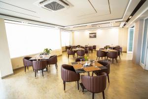 a restaurant with tables and chairs in a room at The Royal Palace Uttara in Dhaka