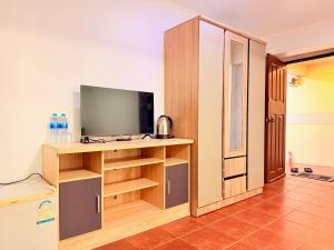 a room with a tv and a cabinet with a television at Vista Inn Patong in Patong Beach