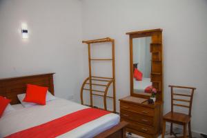 a bedroom with a bed and a mirror and a dresser at Celanika resort in Kandy