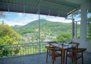 a table and chairs on a balcony with a view at Celanika resort in Kandy