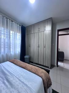 a bedroom with a bed and a large cabinet at Luxury Ntinda Apartment with Wi Fi and Netflix in Kampala
