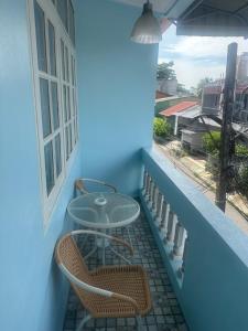 a patio with two tables and chairs on a balcony at Blue House Hat Yai in Hat Yai