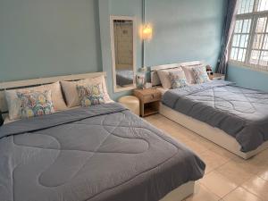 a bedroom with two beds and a mirror at Blue House Hat Yai in Hat Yai