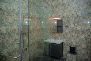 a bathroom with a glass shower and a sink at Celanika resort in Kandy