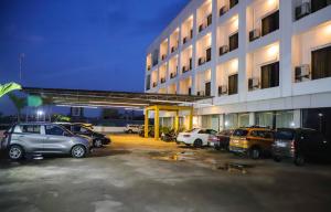 a parking lot with cars parked in front of a building at Hotel Devanshi & Banquets by Classy Stay in Navi Mumbai