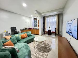 a living room with a green couch and a table at Luxury Ntinda Apartment with Wi Fi and Netflix in Kampala