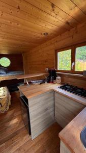a kitchen in a wooden cabin with a stove at Roulotte Providence in Boudeville