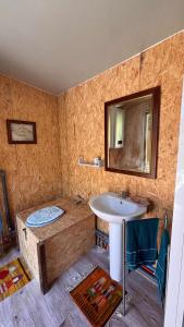 a bathroom with a sink and a tub with a mirror at Roulotte Providence in Boudeville
