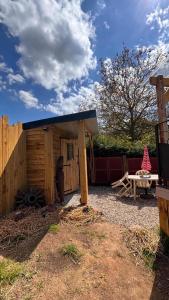 a wooden shed with a picnic table and a bench at Roulotte Providence in Boudeville +2 photos