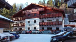 a large building with cars parked in a parking lot at Apartmán Chopok Juh Eva in Tale