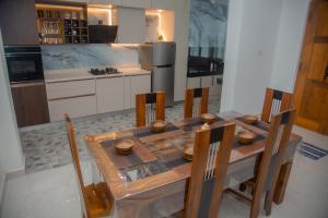 a kitchen with a wooden table with chairs and a refrigerator at Celanika resort in Kandy +2 photos