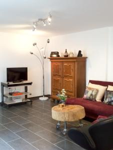 a living room with a red couch and a table at Individuell Wohnen Loft-Charakter im Innenhof in Neuss