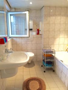 ein Badezimmer mit einem Waschbecken, einem WC und einer Badewanne in der Unterkunft Individuell Wohnen Loft-Charakter im Innenhof in Neuss