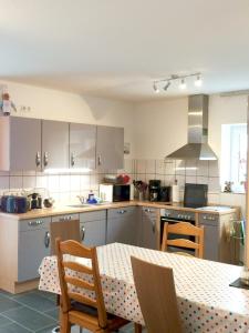 a kitchen with a table and chairs and a table and a kitchen with a table at Individuell Wohnen Loft-Charakter im Innenhof in Neuss