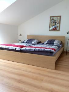 a large bed in a room with a wooden floor at Individuell Wohnen Loft-Charakter im Innenhof in Neuss