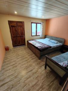 a bedroom with a bed and a wooden floor at Prarambh Cottages in Bhowāli +27 photos