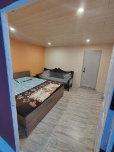 a bedroom with two beds in a room with a door at Prarambh Cottages in Bhowāli