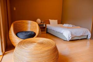 a bedroom with a wicker chair and a bed at Nature Resort in Kawamoto in Kawamoto