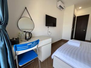 a bedroom with a desk and a mirror and a bed at Arcadia homestay in Phú Quốc