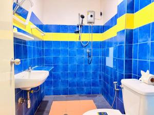 a blue and yellow bathroom with a sink and a toilet at Vista Inn Patong in Patong Beach +109 photos