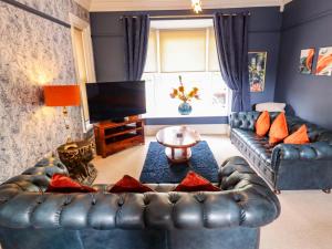 a living room with a leather couch and a television at 105 Spilsby Road in Boston