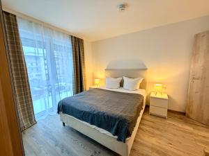 a bedroom with a bed and a large window at GG Apartment 7 in Garmisch-Partenkirchen