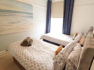 a bedroom with two beds and a painting at 105 Spilsby Road in Boston