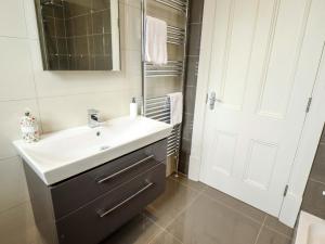 a bathroom with a white sink and a mirror at 105 Spilsby Road in Boston +37 photos
