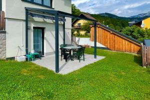 a patio with a table and chairs in a yard at Mitzis Stubn Apartments - Bad Goisern - 24-hour self check-in in Bad Goisern