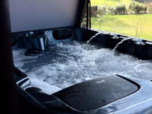 a bath tub filled with water with water at Lodge Osciade in Sibret