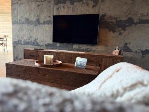 a living room with a flat screen tv on a wall at Lodge Osciade in Sibret
