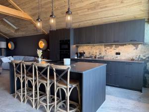 a kitchen with a large island with bar stools at Lodge Osciade in Sibret