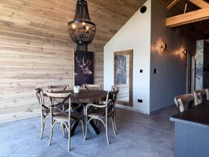 a dining room with a wooden wall at Lodge Osciade in Sibret +15 photos