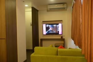 a living room with a green couch and a television at Seaview Holiday Resort in Hong Kong