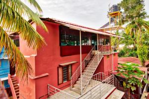 a red building with stairs and a clock tower at Rams Guest House Near Sree Chithra and RCC in Trivandrum