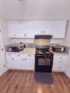 a kitchen with white cabinets and a black stove at Residence Tacoma in Tacoma