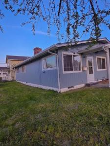 a blue house in a yard with a grass field at Residence Tacoma in Tacoma