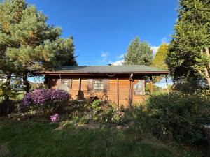 a wooden house with a roof on a yard at Haus Tausendschön in Torgelow
