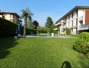 a large yard with a swimming pool in front of a building at Residenz In 1 in Bardolino