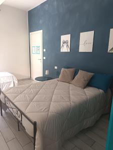 a bedroom with a large bed with a blue wall at Gli Oleandri Rooms Casa Teresa in Conselice