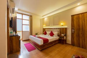 a bedroom with a large bed with red pillows at Hotel Aeroporto in New Delhi +52 photos