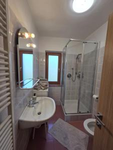 a bathroom with a sink and a shower at Villa Maria - Appartamento vista montagna in Moena +17 photos