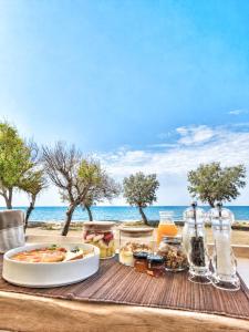a table with food and drinks on the beach at DelMar Suites Syros in Finikas