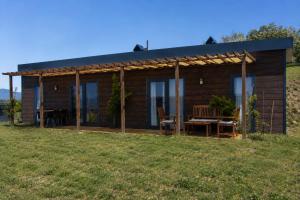 a wooden house with a table and chairs in a field at Loft Orman Tatil Köyü in Ankara