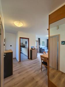 a kitchen and a living room with a table at Villa Maria - Appartamento vista montagna in Moena