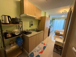 a small kitchen with wooden cabinets and a sink at D Avenue Studio in Iloilo City
