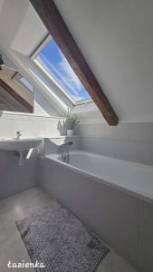 a bathroom with a bath tub and a sink at Syrenka Apartamenty in Ustka +49 photos