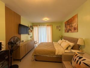 a bedroom with a bed and a couch at D Avenue Studio in Iloilo City